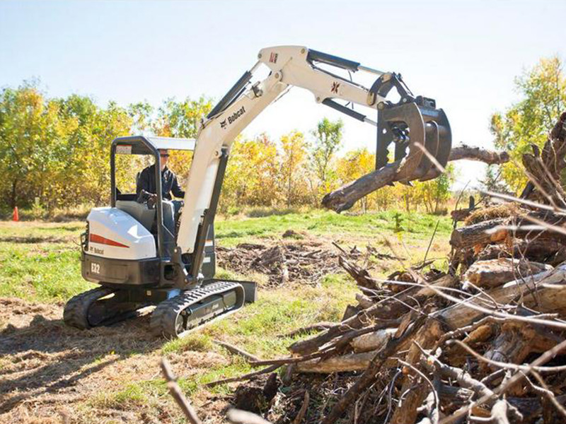 Bobcat E85 Mini Excavator moving tree stumps